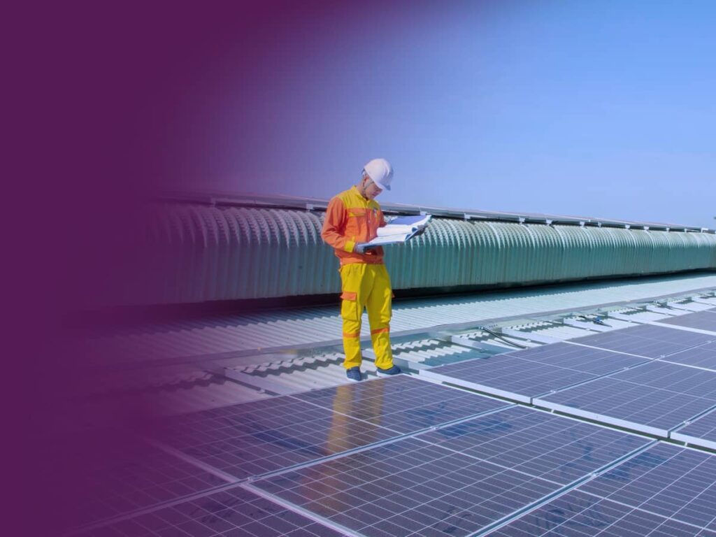 Man standing on solar panels looking at plans